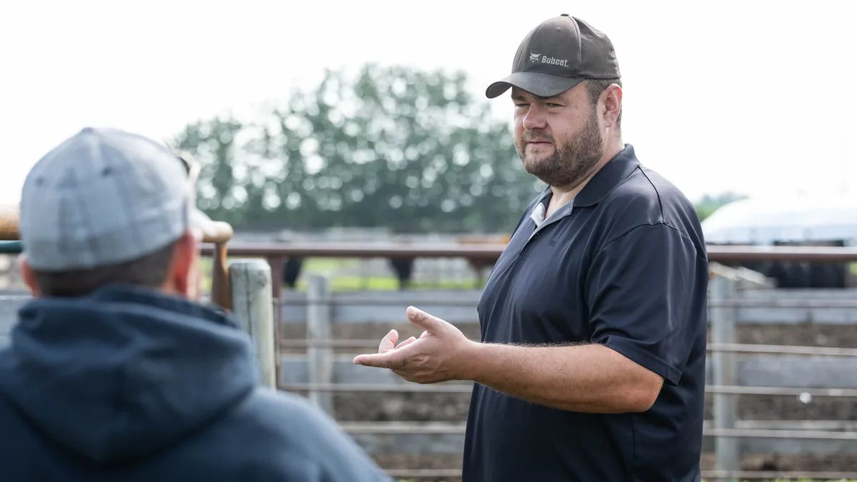 Two cattle producers talking beside the cattle pens on the farm